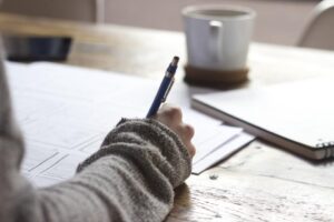 Hand writing business notes at a desk