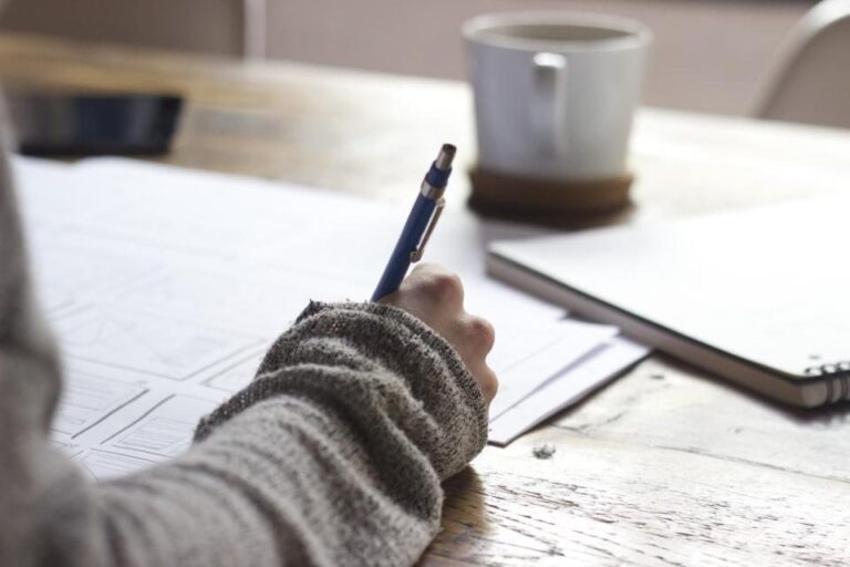 Hand writing business notes at a desk