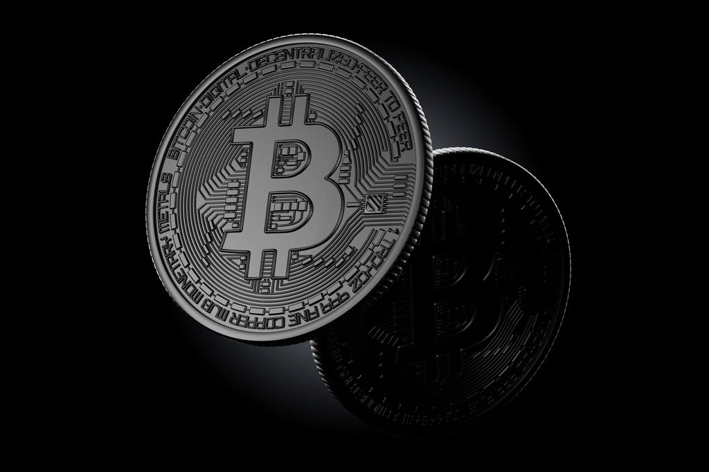 Silver Bitcoin coins on a dark background