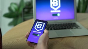 Blockchain app open on a smartphone near a laptop