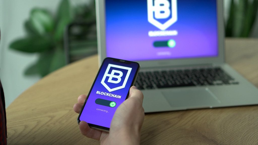 Blockchain app open on a smartphone near a laptop
