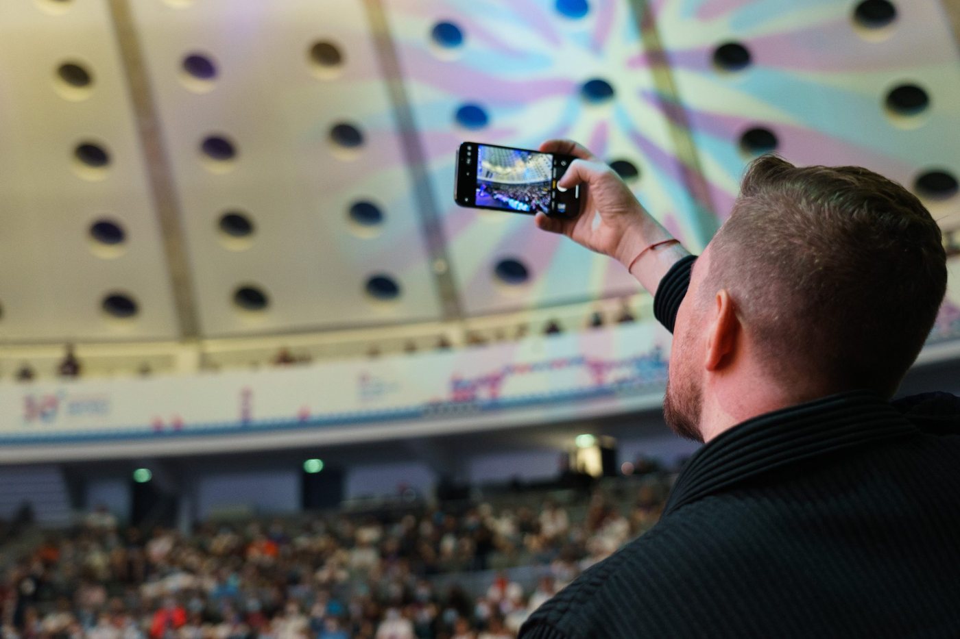 Person photographing a concert with a smartphone