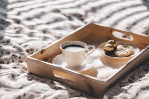 Breakfast tray with coffee and cookies on a bed